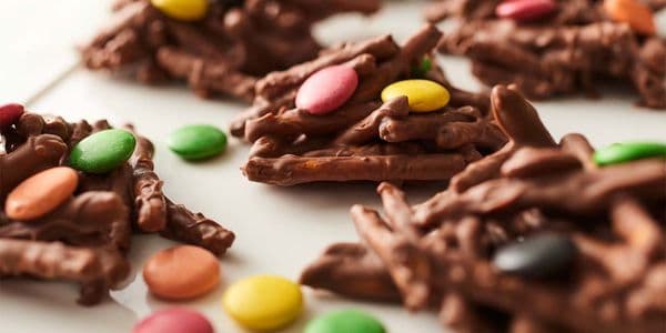 Chokladkluster med färgglada chokladlinser på en vit tallrik.